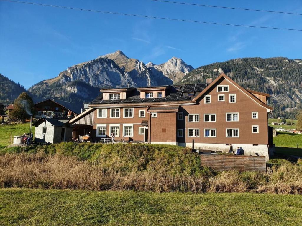 a large house on a hill with mountains in the background at Apartment Bädli by Interhome in Wildhaus