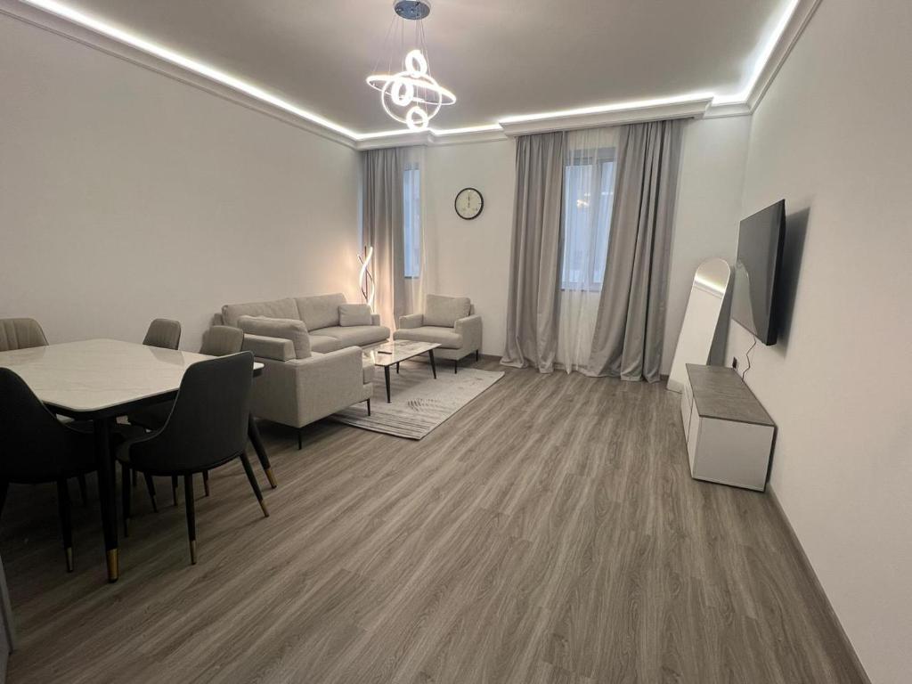 a living room with a couch and a table and chairs at Nasma Homes Al Dana in Abu Dhabi