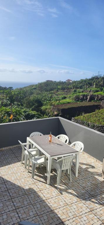 a white table and chairs on a patio with a view at Casa Vereda do Calhau - With barbecue in Campanário