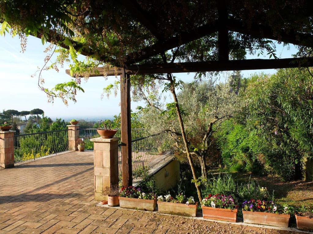 a garden with flowers in pots on a patio at Bellevue, country house in Velletri