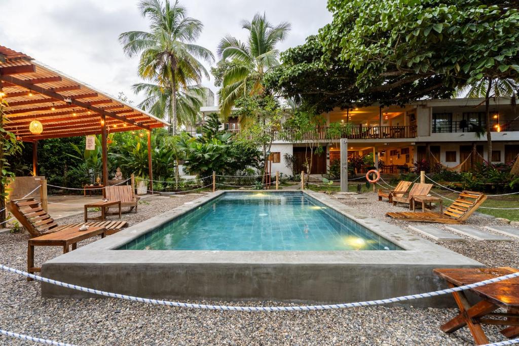 a swimming pool in front of a building with a resort at Casa Chapolin Boutique Guesthouse in Palomino