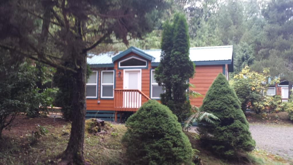 mały domek z drzewami przed nim w obiekcie Tall Chief Camping Resort Cottage 1 w mieście Pleasant Hill