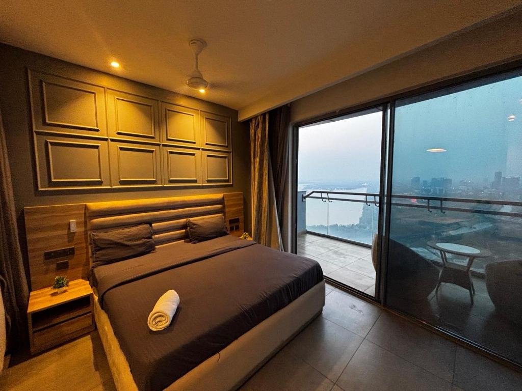 a bedroom with a bed and a large window at Supernova spira in Noida