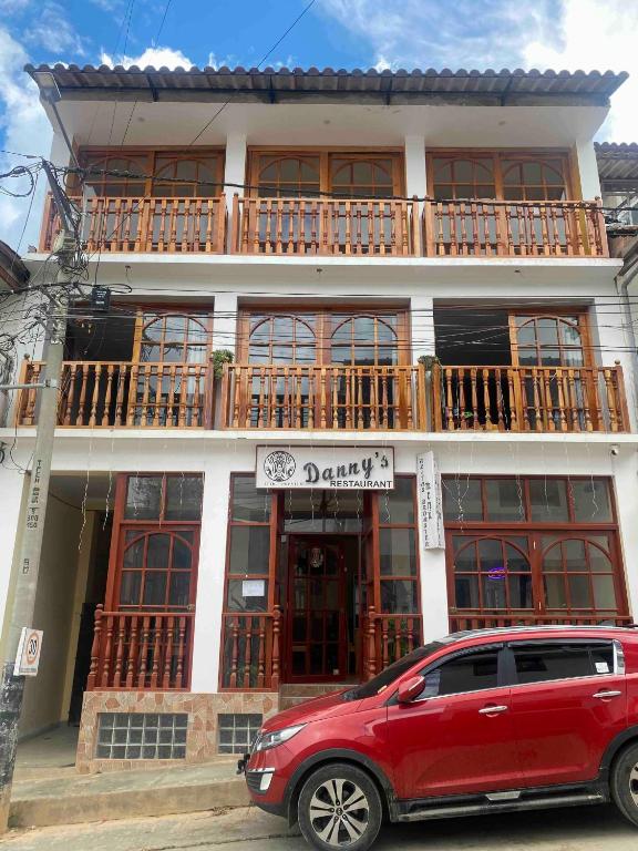 a red suv parked in front of a building at Attic Hotel in Chachapoyas