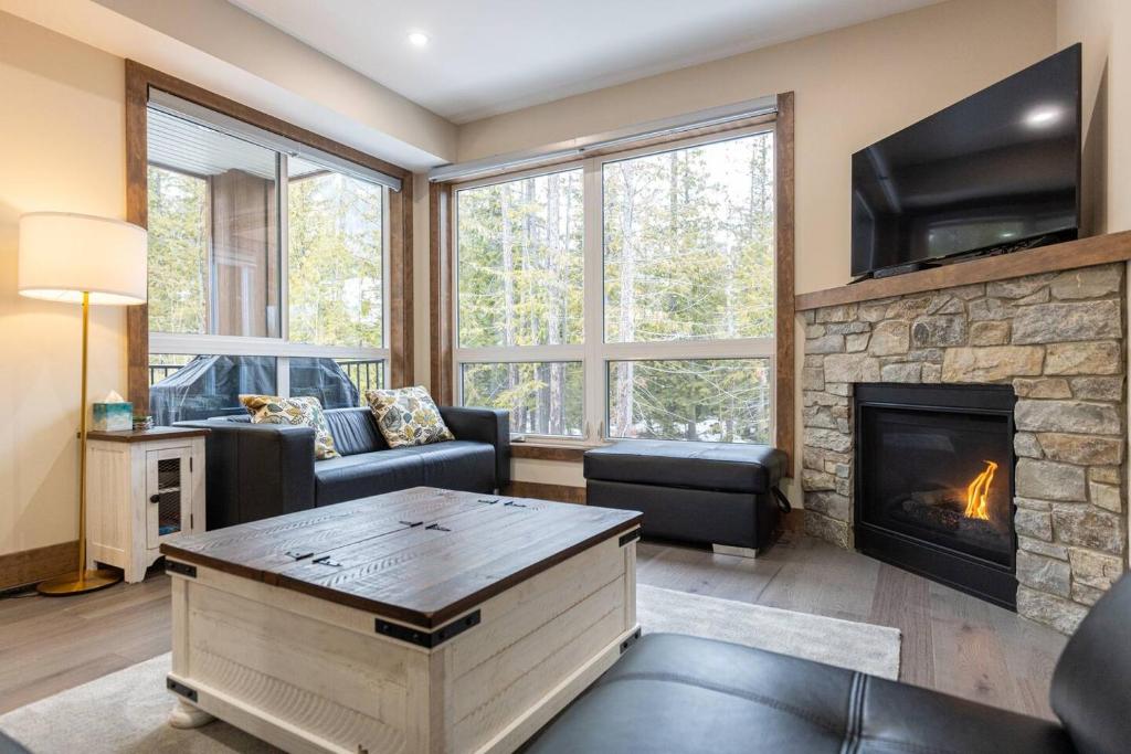a living room with a fireplace and a tv at Polar Peak Lodges by Fernie Central Reservations in Fernie