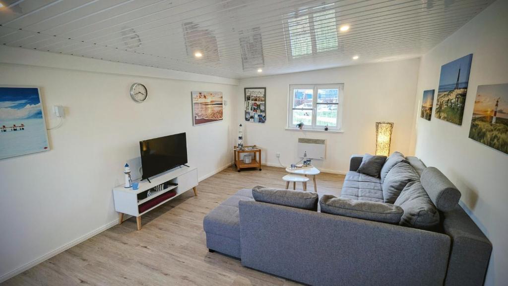 a living room with a couch and a flat screen tv at Ferienwohnung Dennis in Nordleda