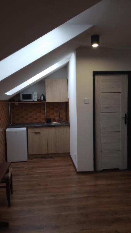 an empty room with a door and a kitchen at Chmurka in Bęczków