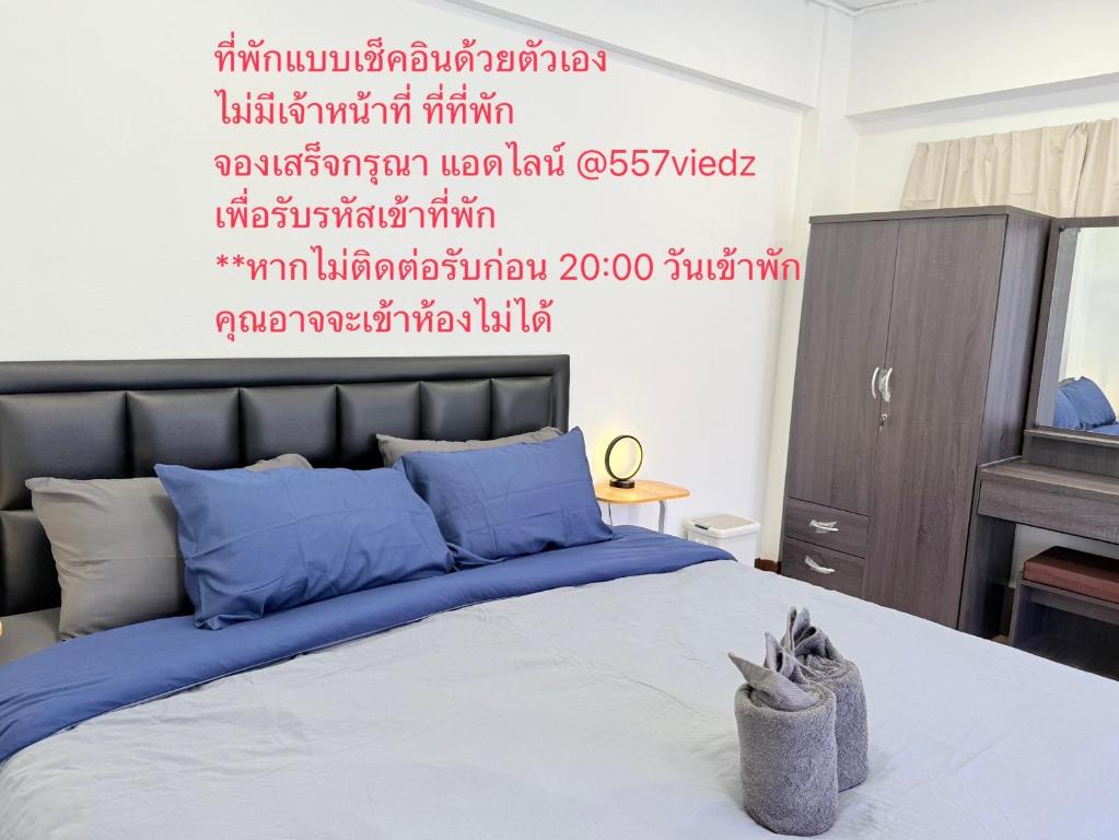 a bedroom with a bed with red writing on the wall at เทพกุญชร Budget-Friendly Room in Ban Lam Rua Taek