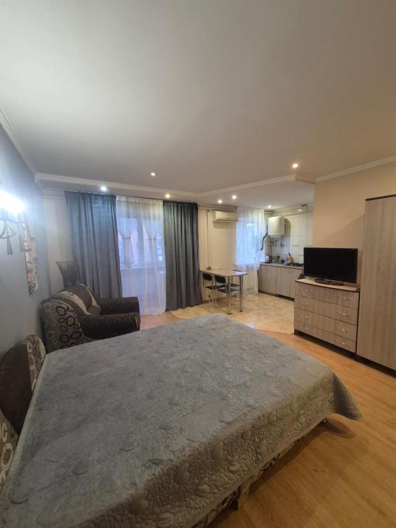 a bedroom with a large bed and a living room at Апартаменты in Izmail
