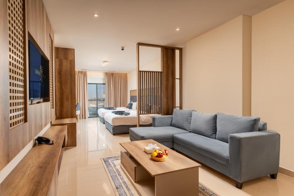 a living room with a couch and a bed at Golden Pillar Hotel in Aqaba