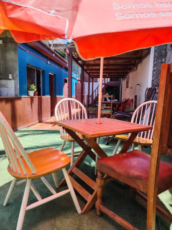 a table and chairs with an umbrella on a patio at Iquique Backpackers Beach House in Iquique