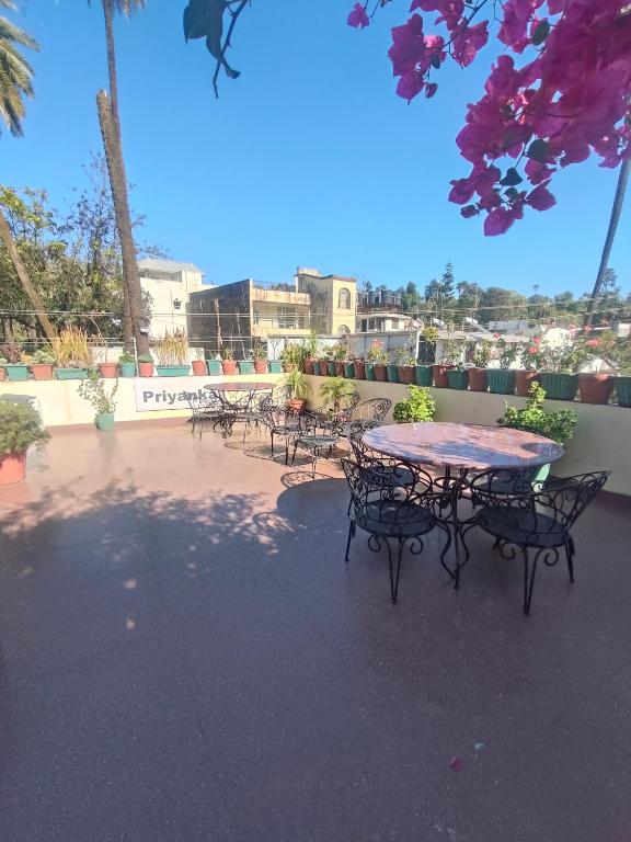 a patio with a table and chairs on a sidewalk at Hotel Priyanka - 750 metres from nakki lake Near Bus Stand in Mount Ābu