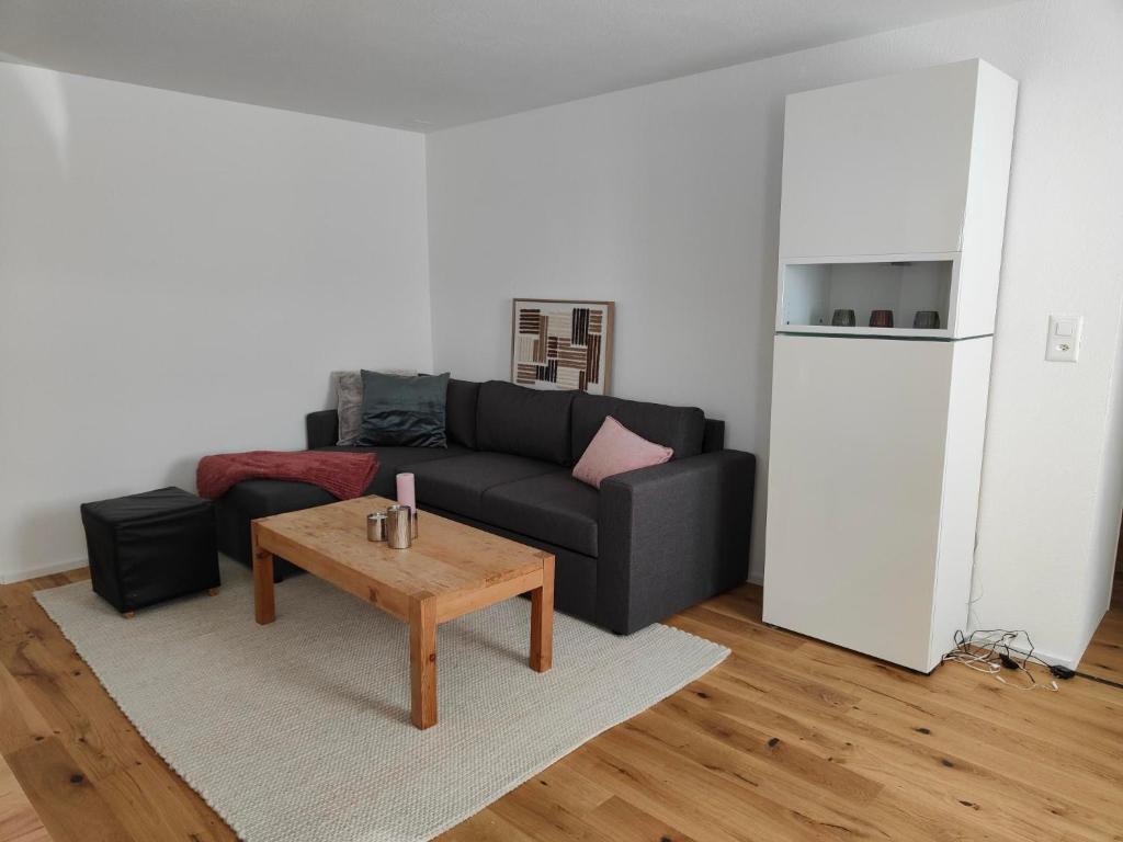 a living room with a black couch and a table at Apartment Günter by Interhome in Sagogn