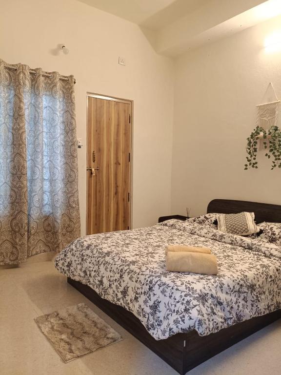 a bedroom with a bed with a comforter on it at Casa Iris - One Bedroom in a 3BHK Apartment in Hyderabad