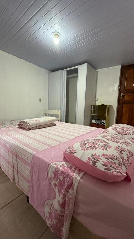a bedroom with a large bed with a pink blanket at Suites da Bela 01 Caparaó in Caparaó Velho
