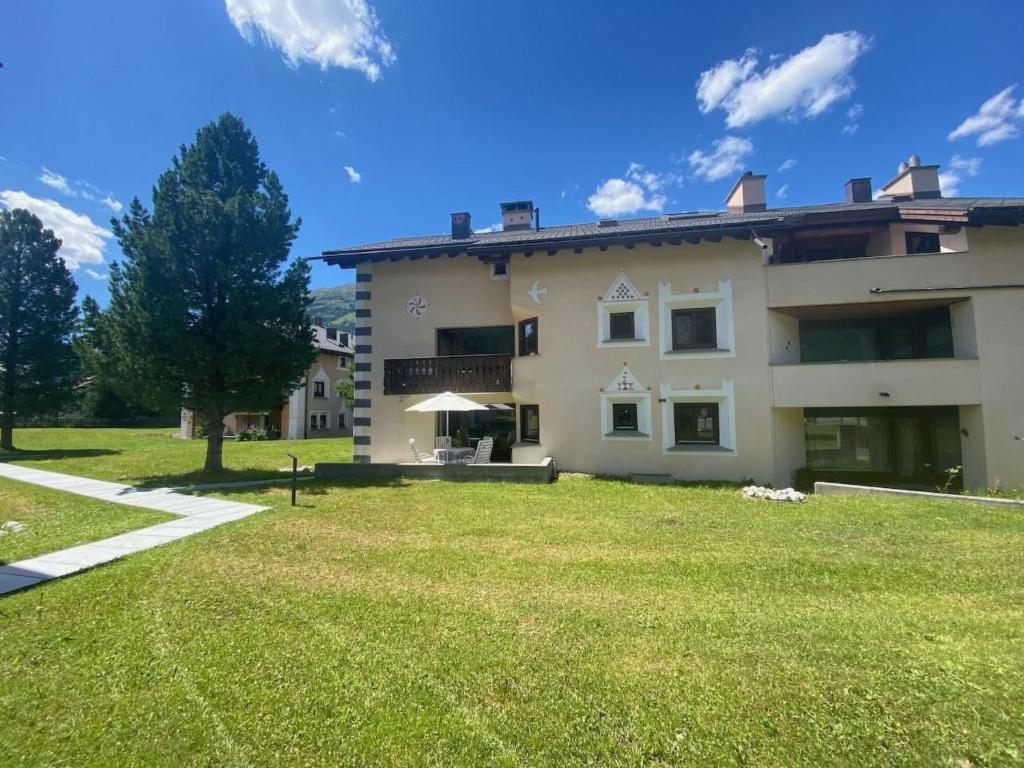 a house with a large yard in front of it at Apartment Sassella 2a by Interhome in La Punt-Chamues-ch