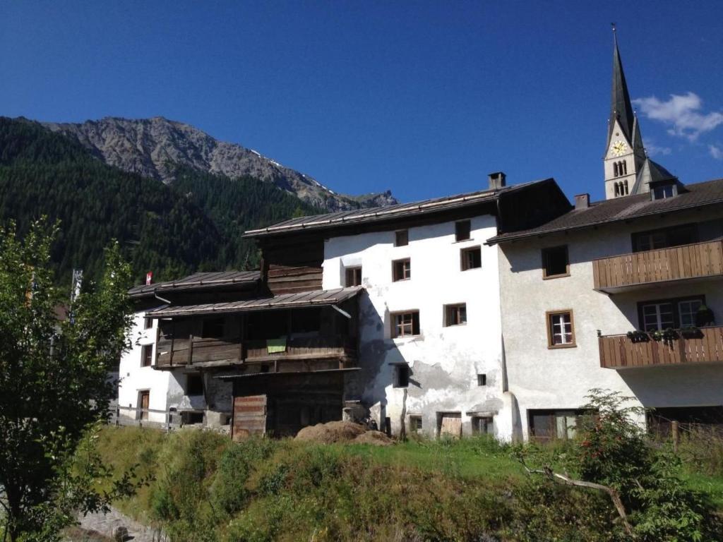 a large white building with a church in the mountains at Apartment Chasa Jaro by Interhome in Santa Maria Val Müstair