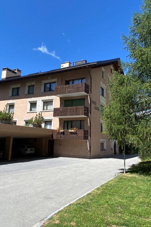 a building with a parking lot in front of it at Apartment Wohnung Curtins by Interhome in Pontresina