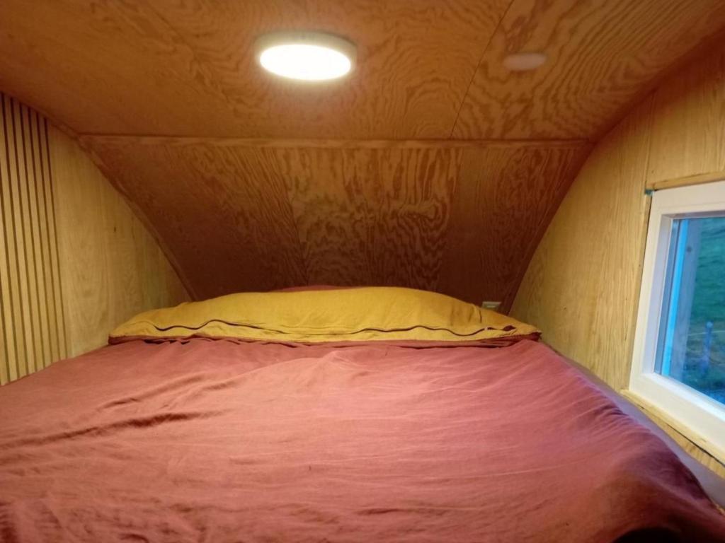 a bed in a small room with a yellow pillow at Holiday Home Tiny Hause by Interhome in St. Gallen