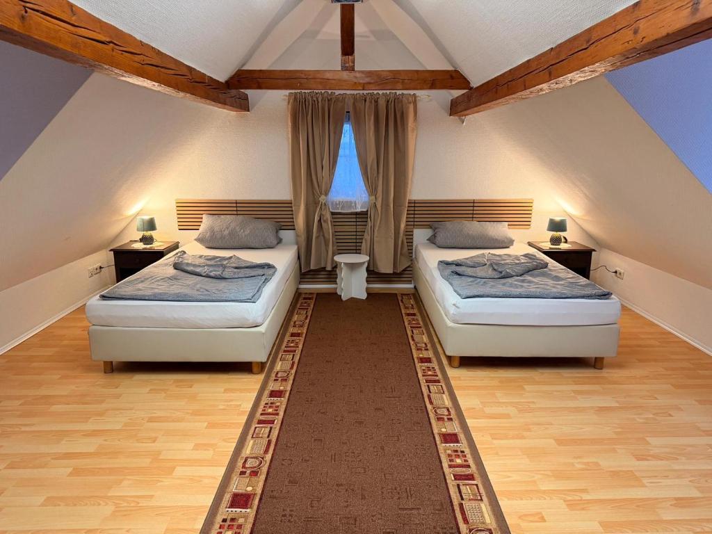 two beds in a attic room with two windows at Monteur Darius in Spiesheim