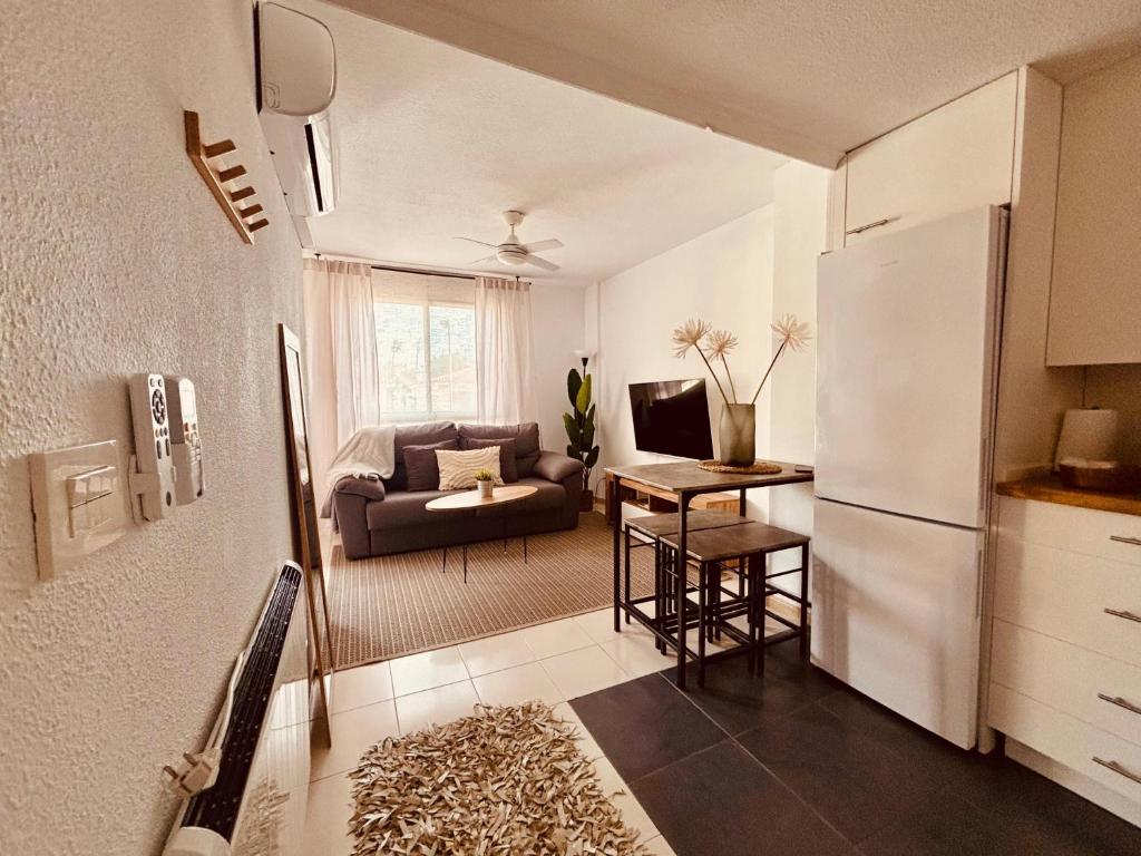 a kitchen and living room with a couch and a refrigerator at Costa Flow Apto Benicasim in Benicàssim