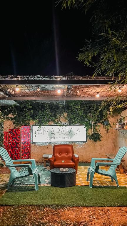 a chair and two chairs sitting in front of a sign at Agriturismo Amarasca in Gagno