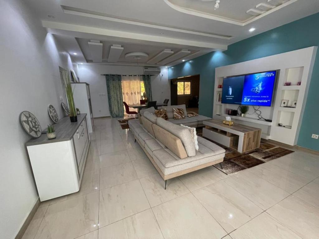 a large living room with a couch and a tv at Villa Aida in Djilore