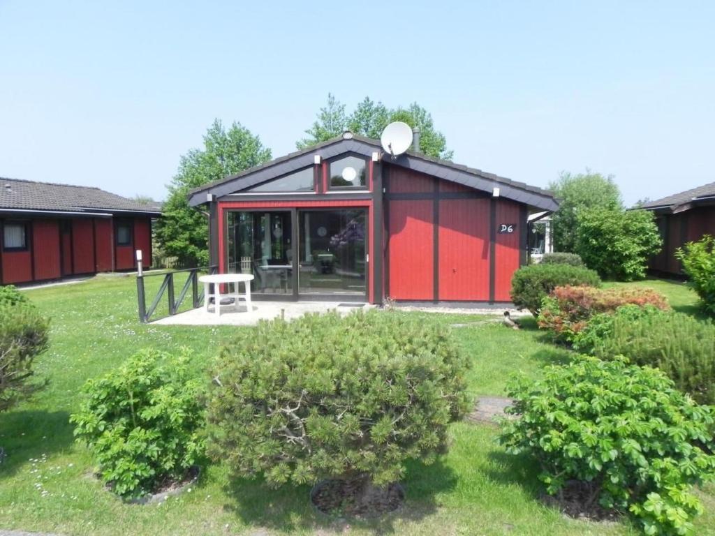 a red and black building in a yard at Holiday Home by Interhome in Großwürden