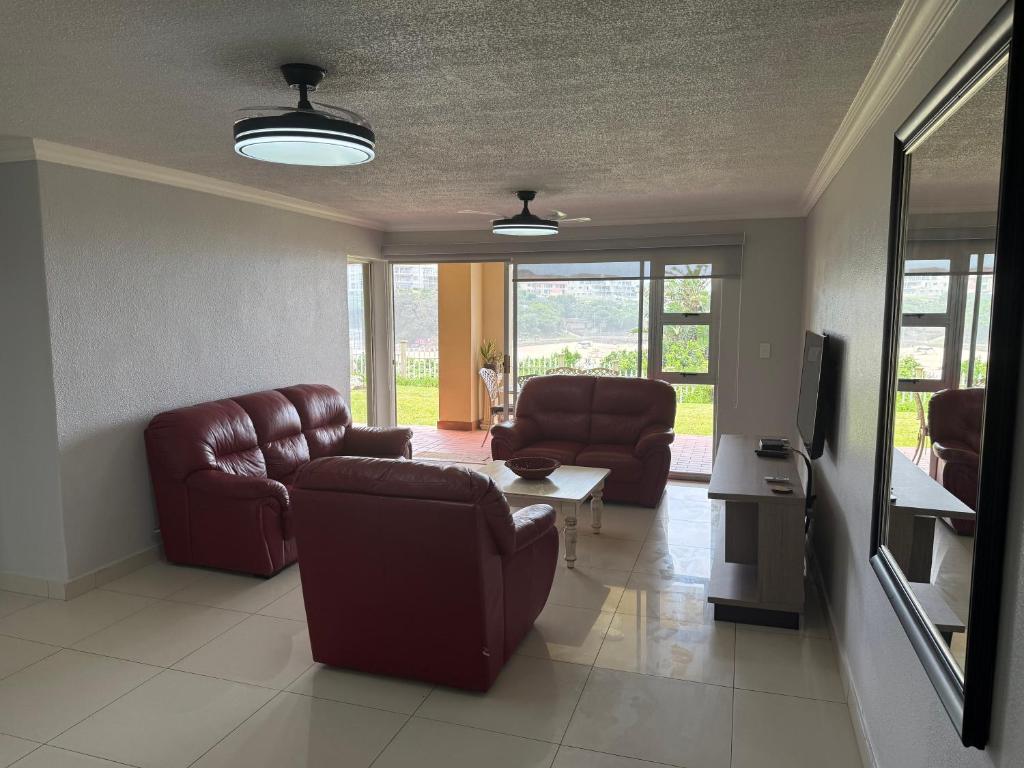 a living room with a couch and chairs and a table at 34 Laguna La Crete in Uvongo Beach
