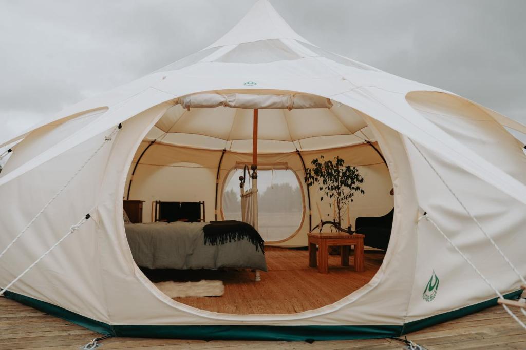 a white tent with a bed in a room at Kay Bell in Masterton