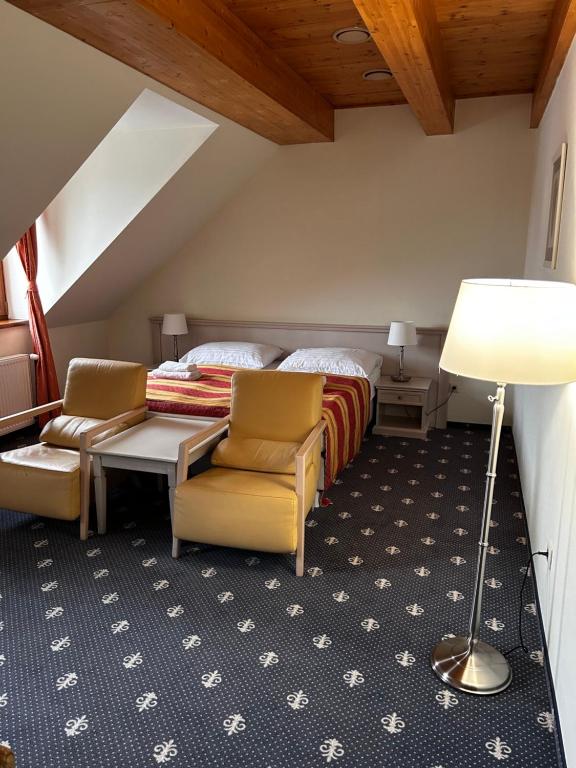 a bedroom with a bed and a table and chairs at Hotel Hradna brana in Bratislava