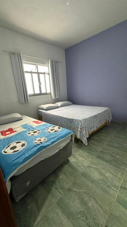 a bedroom with two beds and a window at Suites da Bela 02 Caparaó in Caparaó Velho