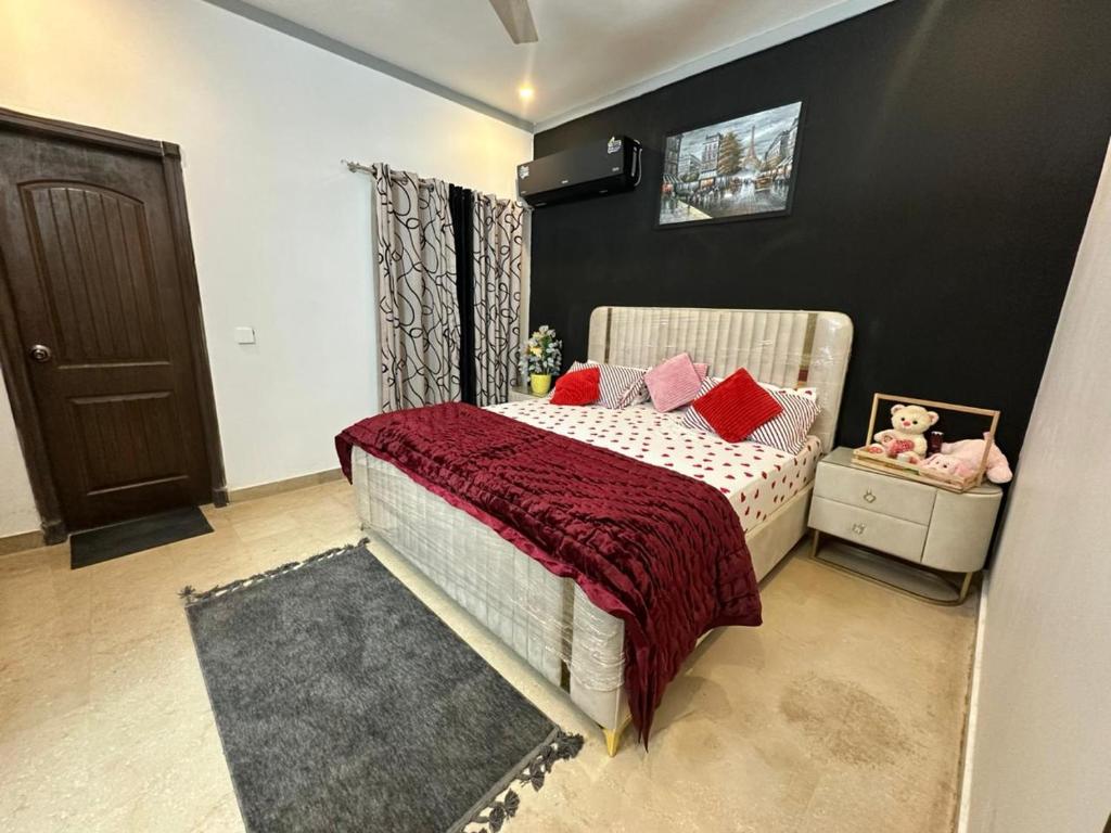 a bedroom with a bed with red pillows at AuraStays in Dargai