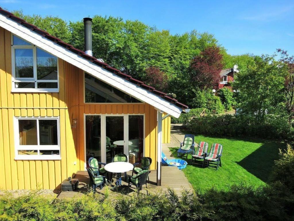 a yellow house with a patio with chairs and a table at Holiday Home Lea by Interhome in Bremke