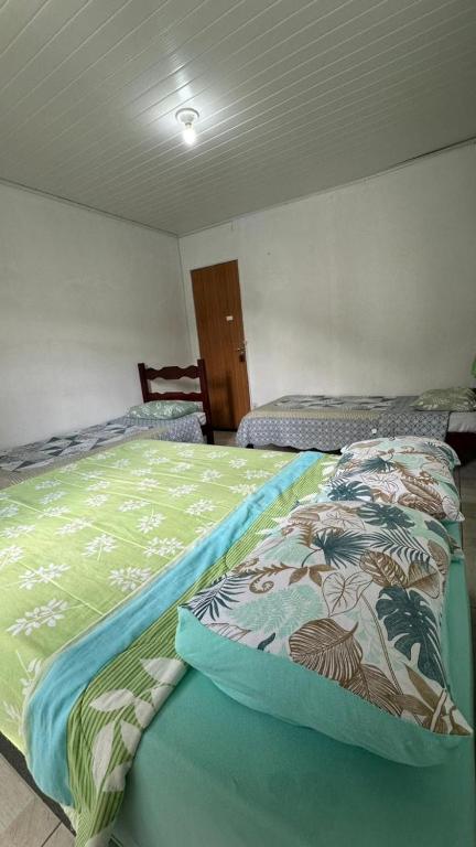 a bedroom with a bed with a comforter on it at Suites da Bela 03 Caparaó in Caparaó Velho