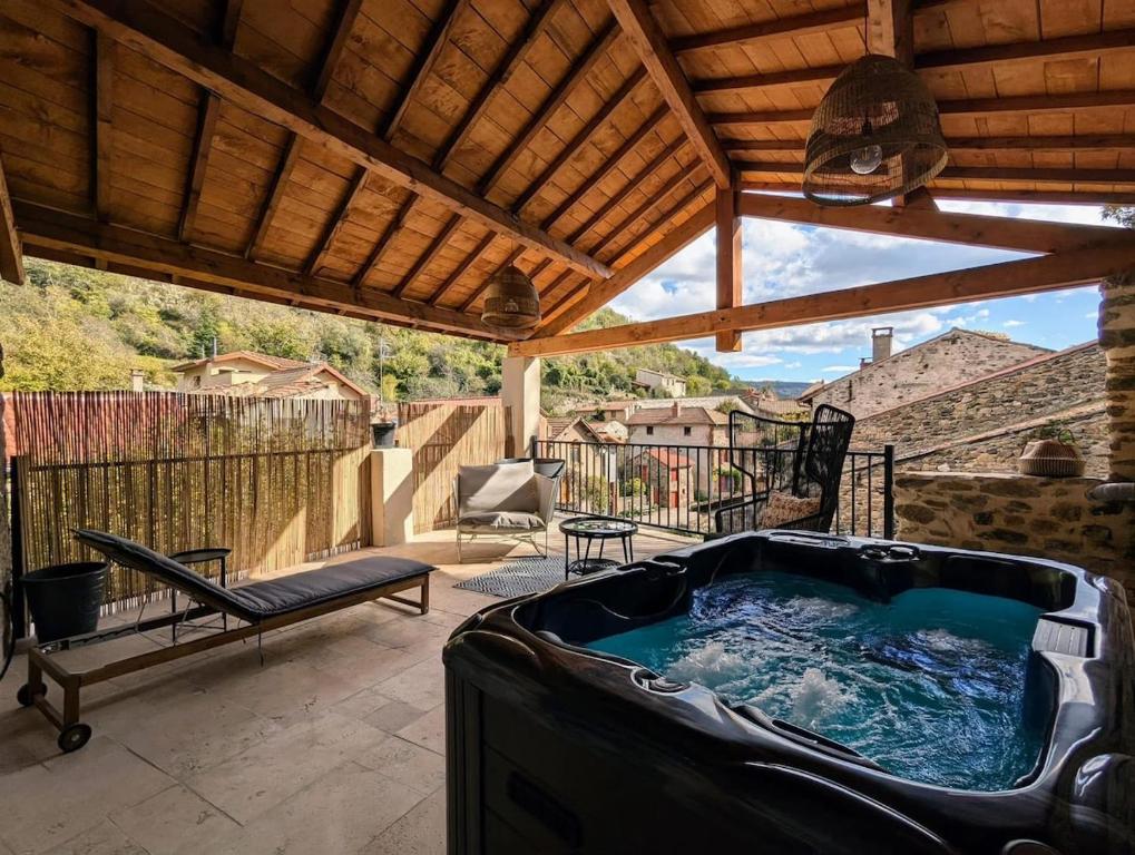 a hot tub on the patio of a house at Maison de charme - Le Palha in Blesle