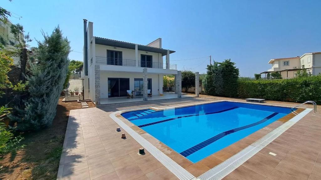 a large swimming pool in front of a house at Seaview Villa Theologos in Theologos