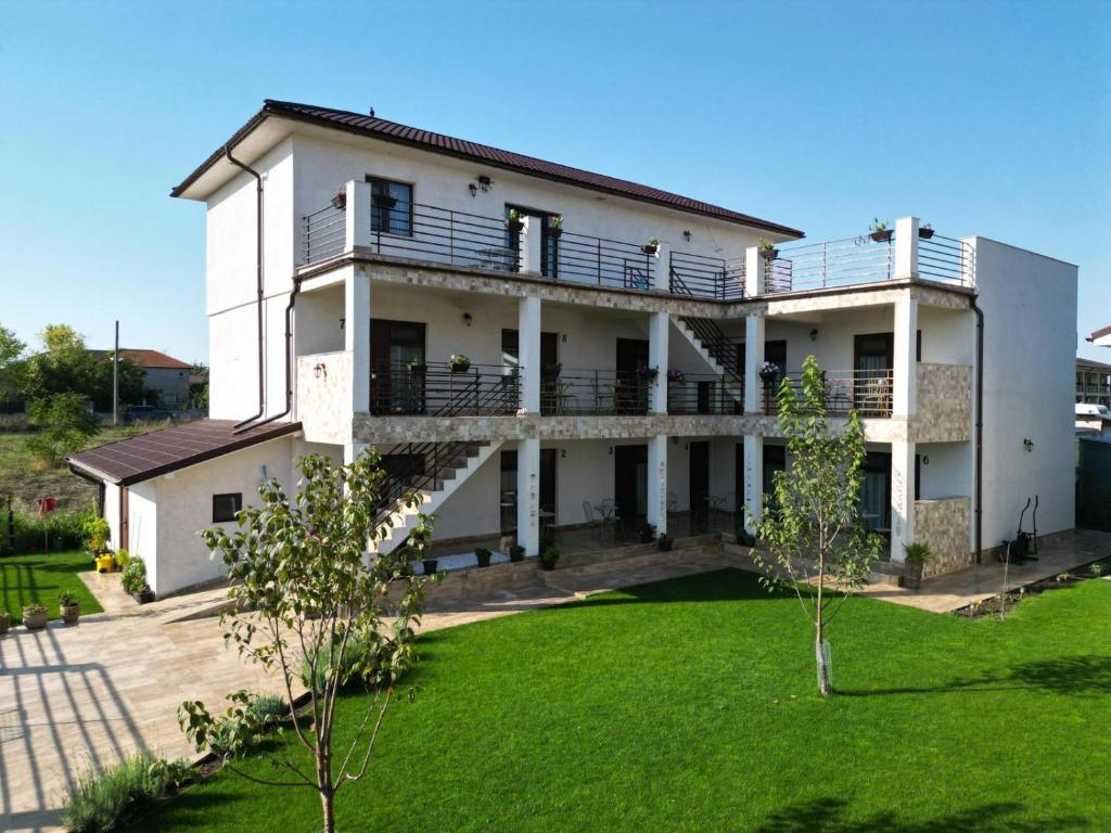 a large white house with a green yard at Casa Giulia in Vama Veche