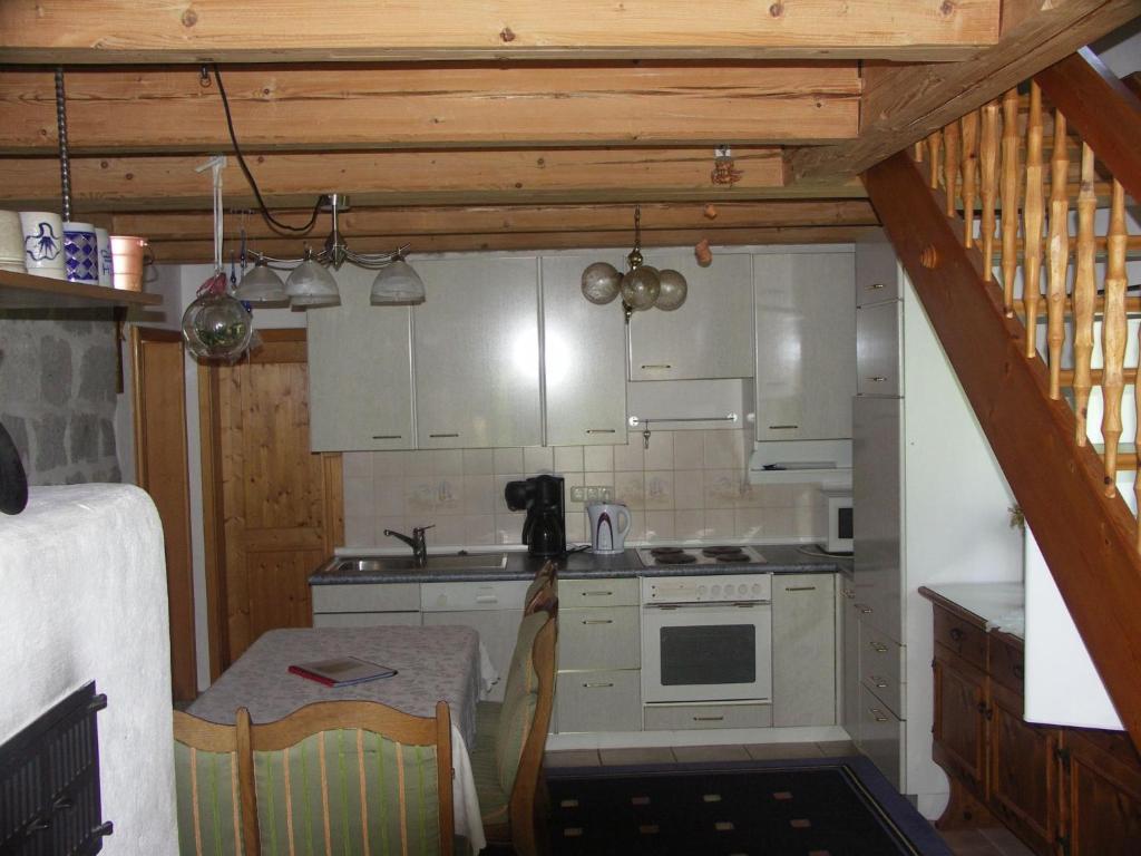 a small kitchen with white cabinets and a table at Apartment Ausgebaute Scheune by Interhome in Kollnburg