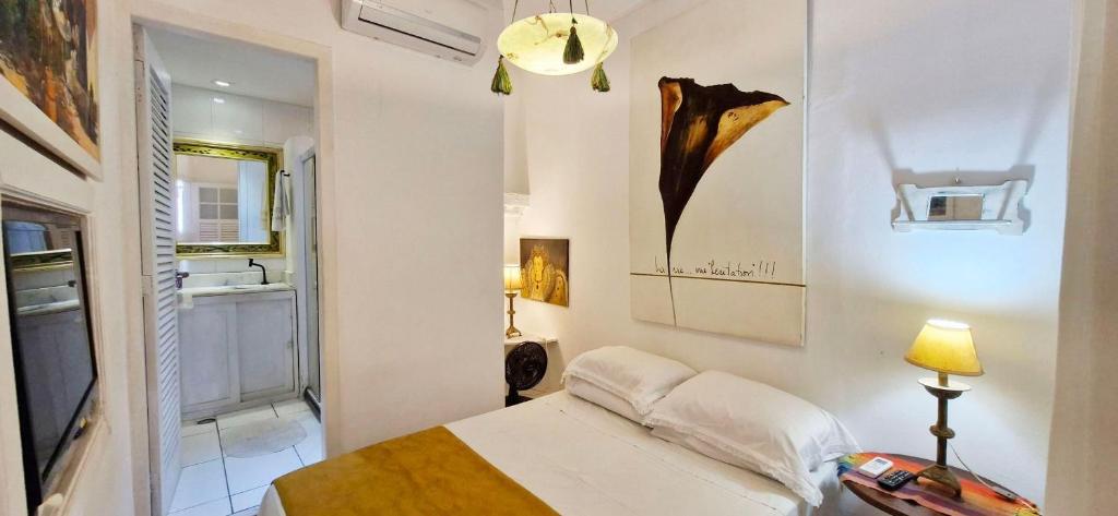 a bedroom with a bed and a table and a lamp at COPSE0102 - Edifício Themis in Salvador