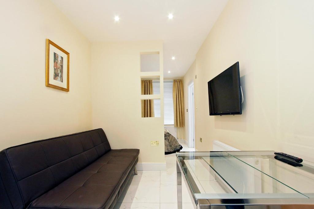 a living room with a couch and a glass table at Hyde Park Serviced Rooms in London