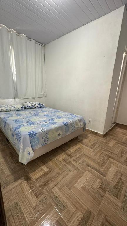 a bedroom with a bed and a wooden floor at Suites da Bela 06 Caparao in Caparaó Velho