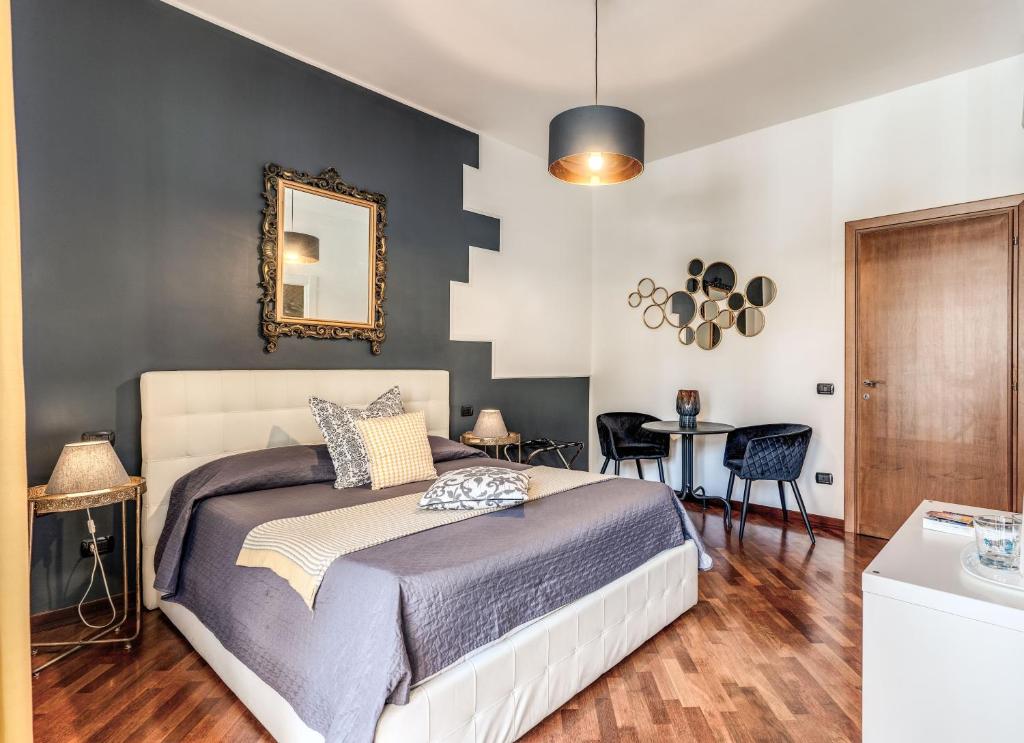 a bedroom with a bed and a mirror and a table at Stasera a casa da M.E. in Rome