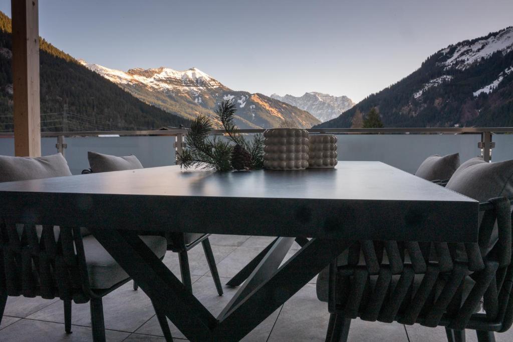a table and chairs on a balcony with mountains at Bomwäldele 89 in Bichlbach