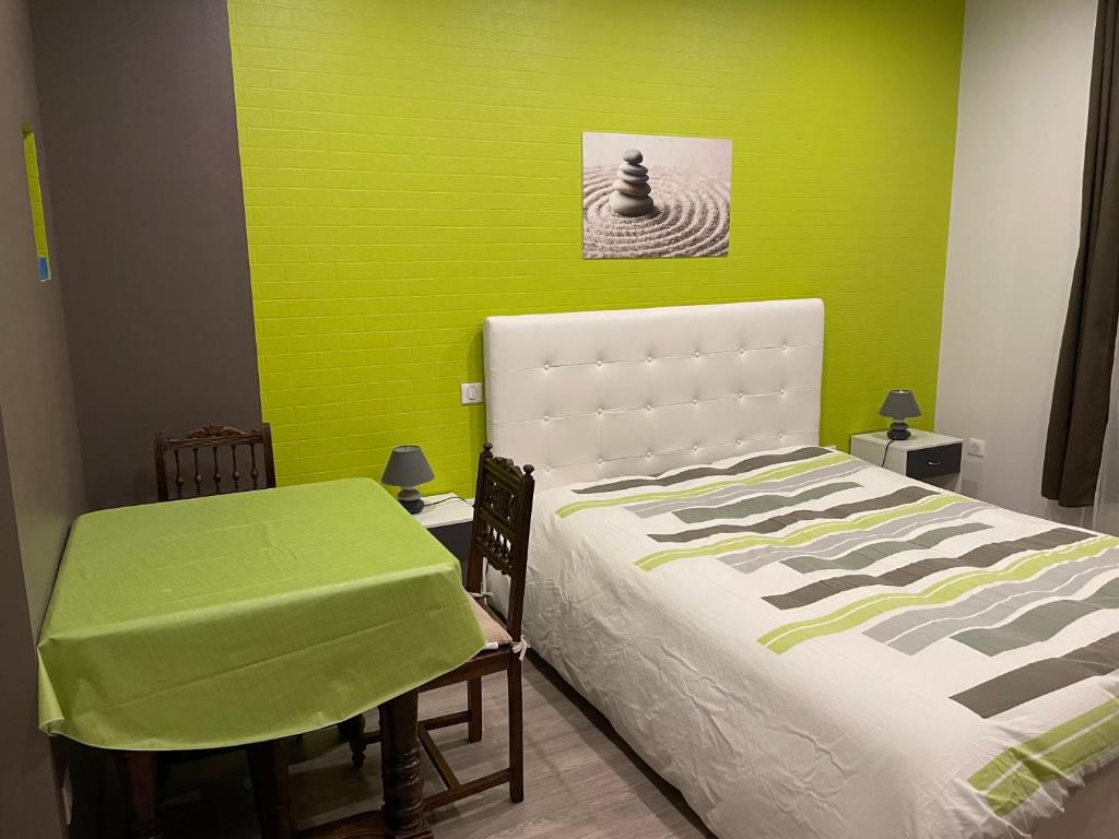 a bedroom with a bed and a green wall at L'Envolée - Spacieux, 2 personnes in Horbourg