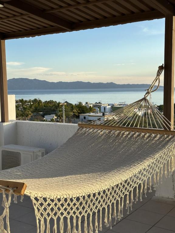 a hammock on a balcony with a view of the ocean at Bed and Cactus - Ocean View Villa in El Sargento