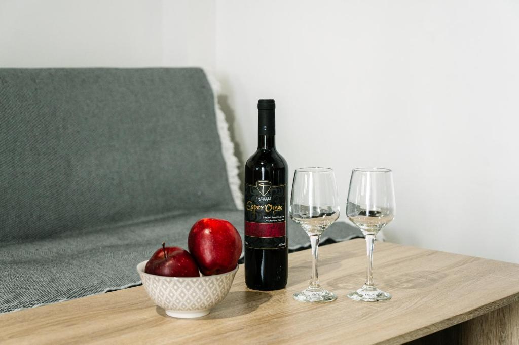 a bottle of wine and two glasses on a table at Rhodes Central Apartment in Rhodes Town