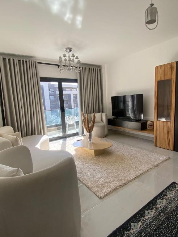 a white living room with a couch and a table at loved modern home 2BR in New cairo