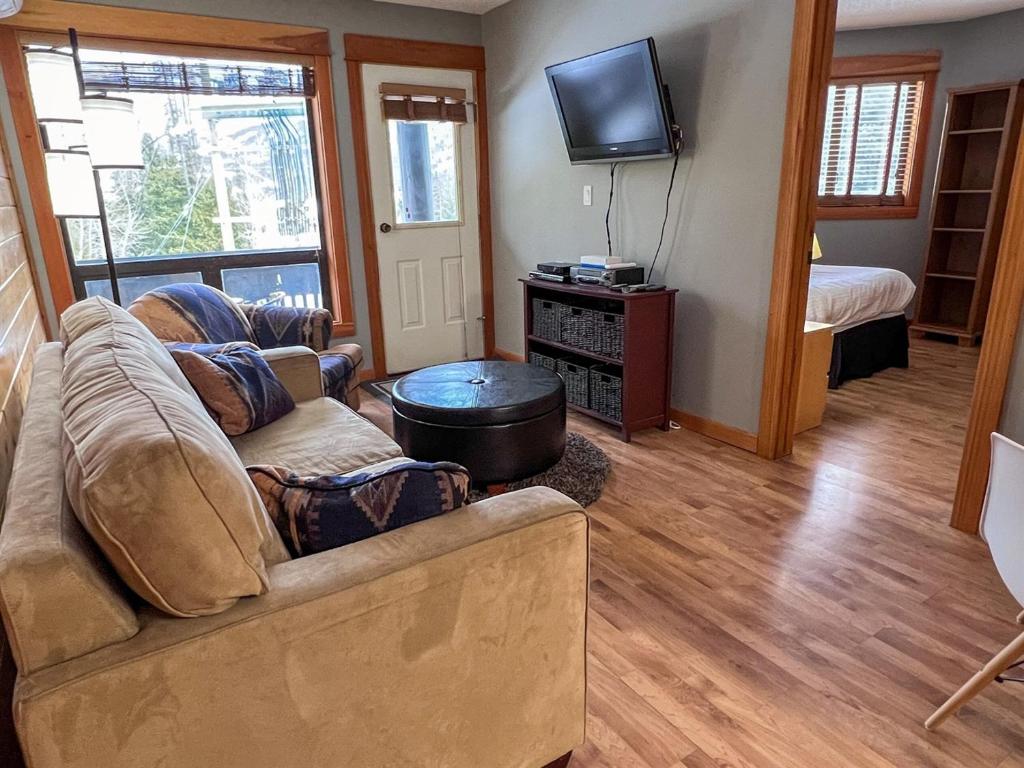 a living room with a couch and a television at Griz Inn by Fernie Central Reservations - Right on The Slopes in Fernie