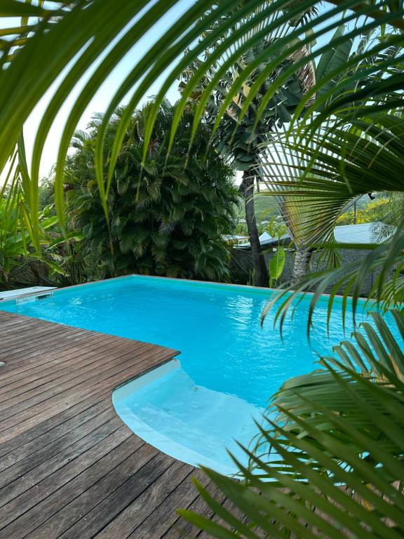 a swimming pool next to a wooden deck at Maryvent Apartment in Sainte-Anne